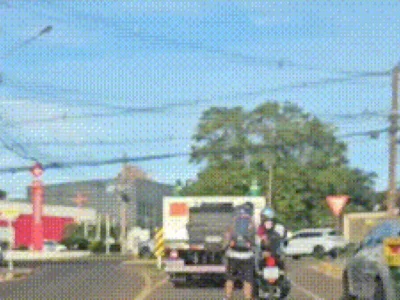 Brazil motorcyclist tows inline skater in suburban street